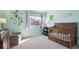Light blue bedroom with crib, alphabet wall decorations and large window at 4175 S Andes St, Aurora, CO 80013