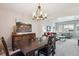 Open-concept dining room featuring a dark wood table and chairs with a view into the bright living room at 4175 S Andes St, Aurora, CO 80013