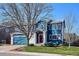 Charming two-story home featuring a red door, blue siding, an attached garage, and a well-maintained lawn at 4175 S Andes St, Aurora, CO 80013