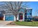Charming two-story home featuring a red door, blue siding, an attached garage, and a well-maintained lawn at 4175 S Andes St, Aurora, CO 80013