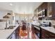 Well-equipped kitchen with stainless steel appliances, dark cabinetry, and a view into a bright breakfast nook at 4175 S Andes St, Aurora, CO 80013