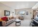 Bright living room featuring a large bay window, neutral-toned furniture, and a stylish round coffee table at 4175 S Andes St, Aurora, CO 80013
