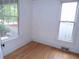 Bedroom with hardwood floors, white walls, and a garden view through the windows at 1346 S Logan St, Denver, CO 80210