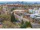 Sweeping aerial view of property with Denver skyline and city neighborhood; tree lined streets at 795 N Jersey St, Denver, CO 80220