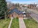 Aerial view of a brick home boasting a well-manicured lawn and a cozy backyard retreat at 795 N Jersey St, Denver, CO 80220
