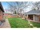 A well-manicured lawn complements the brick home, leading to a charming covered patio area, perfect for outdoor enjoyment at 795 N Jersey St, Denver, CO 80220