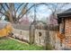 Wooden fence adorned with an arched gate and blooming trees provides privacy and charm to this inviting backyard space at 795 N Jersey St, Denver, CO 80220