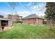 Brick home featuring a well-maintained lawn, privacy fence, and a versatile storage shed in the backyard at 795 N Jersey St, Denver, CO 80220