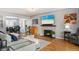 Inviting living room with a cozy fireplace, modern decor, hardwood floors, and open layout to the dining area at 795 N Jersey St, Denver, CO 80220
