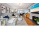 Bright living room featuring a fireplace, hardwood floors, and an open floor plan flowing into the dining area at 795 N Jersey St, Denver, CO 80220