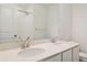 Bathroom featuring double sinks, quartz countertop, and shower with white tile at 8339 Snake River St, Littleton, CO 80125