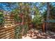 Wooden back deck enclosed with decorative fencing, vegetation, and shade trees at 5416 S Hannibal Ct, Centennial, CO 80015