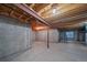 Unfinished basement featuring concrete walls, concrete floor, and exposed wood beams with updated lighting at 5416 S Hannibal Ct, Centennial, CO 80015