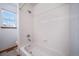 Bright bathroom features a white tiled shower over tub, toilet, and window at 5416 S Hannibal Ct, Centennial, CO 80015