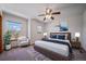 Well-lit bedroom featuring a large bed with blue pillows and a ceiling fan at 5416 S Hannibal Ct, Centennial, CO 80015