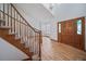 Elegant foyer featuring hardwood floors, a staircase with carpeted steps, and a front door with decorative glass panels at 5416 S Hannibal Ct, Centennial, CO 80015