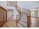Spacious foyer with hardwood floors, a curved staircase, and natural light, creating a welcoming entry to the home at 5416 S Hannibal Ct, Centennial, CO 80015