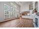 Sun-filled living room with fireplace, hardwood floors, tall windows, and an open view to the kitchen creating an inviting space at 5416 S Hannibal Ct, Centennial, CO 80015