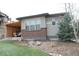 A landscaped backyard with a covered patio, artificial turf and rock features offers a welcoming outdoor space at 10526 Fairhurst Way, Highlands Ranch, CO 80126