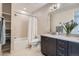 Spacious bathroom with double vanity, shower-tub combo, and convenient built-in shelving at 10526 Fairhurst Way, Highlands Ranch, CO 80126