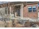 Inviting front porch with brick accents, a modern front door, and decorative landscaping at 10526 Fairhurst Way, Highlands Ranch, CO 80126