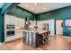 Gourmet kitchen featuring a spacious island with seating, custom cabinetry, and stainless steel appliances at 10526 Fairhurst Way, Highlands Ranch, CO 80126