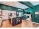 Open-concept gourmet kitchen with stainless steel appliances that flows into the living room with fireplace at 10526 Fairhurst Way, Highlands Ranch, CO 80126