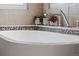 Close-up of a luxurious soaking tub with modern faucet and mosaic tile surround at 5310 S Flanders Way, Centennial, CO 80015