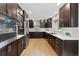 Modern kitchen featuring stainless steel appliances, dark wood cabinets, and white countertops at 5310 S Flanders Way, Centennial, CO 80015