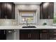 Well-lit kitchen sink with mosaic backsplash and modern faucet at 5310 S Flanders Way, Centennial, CO 80015