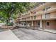 Multi-story building featuring large balconies and mature trees around the property at 2225 Buchtel Blvd # 208, Denver, CO 80210