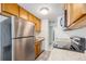 Modern kitchen with stainless steel refrigerator and appliances, granite countertop, and wood cabinets at 2225 Buchtel Blvd # 208, Denver, CO 80210