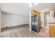 Open-concept living room with wood-look flooring, neutral walls, and kitchen access at 2225 Buchtel Blvd # 208, Denver, CO 80210