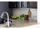 Close-up on countertops and backsplash featuring dark cabinets, light countertops and a subway tile backsplash at 1280 Fairfax St, Denver, CO 80220