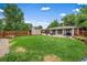 Expansive backyard featuring a lush lawn, patio, storage shed, and mature trees, perfect for outdoor living at 5490 E Kentucky Ave, Denver, CO 80246