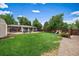 Spacious backyard with patio, lush green lawn, play area, and mature trees; great for outdoor enjoyment at 5490 E Kentucky Ave, Denver, CO 80246
