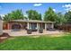 Expansive backyard with brick patio, lush lawn, outdoor seating, and mature trees provides great space at 5490 E Kentucky Ave, Denver, CO 80246
