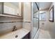 The tiled bathroom is complete with a glass shower, modern vanity, and decorative mirror at 5490 E Kentucky Ave, Denver, CO 80246