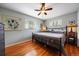 This cozy bedroom features hardwood floors, a metal bed frame, and soft, natural lighting at 5490 E Kentucky Ave, Denver, CO 80246