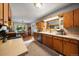 This cozy kitchen features wooden cabinets, stainless steel appliances, and a geometric patterned rug at 5490 E Kentucky Ave, Denver, CO 80246