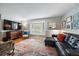 Comfortable living room with a bay window, hardwood floors, and a stylish black leather couch at 5490 E Kentucky Ave, Denver, CO 80246