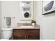 Powder room features a granite-top vanity, framed mirror, and a toilet, creating a functional space at 2925 S Harrison St, Denver, CO 80210