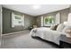 Cozy bedroom with neutral carpet and olive green walls, featuring windows with natural light and decorative elements at 2925 S Harrison St, Denver, CO 80210