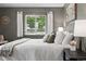 Cozy bedroom featuring a comfortable bed with many pillows and a sunny window view at 2925 S Harrison St, Denver, CO 80210