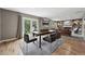 Open-concept dining area with wood floors, adjacent living room, and natural light from French doors at 2925 S Harrison St, Denver, CO 80210