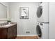 A bright, efficiently designed laundry area featuring a vanity and stacked front-load washer and dryer set at 2925 S Harrison St, Denver, CO 80210