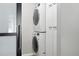 Modern, stacked washer and dryer set with white cabinets providing streamlined convenience at 2925 S Harrison St, Denver, CO 80210