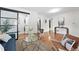 Open-concept living room with hardwood floors, modern furniture, and a sliding door to laundry closet at 2925 S Harrison St, Denver, CO 80210