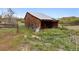 Rustic wooden barn with a weathered exterior, nestled in a tranquil, grassy setting at 2938 Wolfensberger Rd, Sedalia, CO 80135