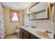 Well-lit bathroom with double sinks, large mirror, and decorative shower curtain at 2938 Wolfensberger Rd, Sedalia, CO 80135